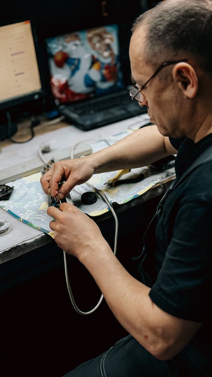 Mastering the First Impression: Your intriguing post title goes here Technician focused on repairing electronic device at a cluttered desk with tools and components.